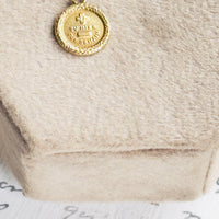 Antique gold charm necklace shown on neutral background