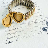 Open heart locket on sweetheart bracelet revealing space for two tiny photos.