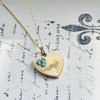 Antique 9ct gold heart pendant necklace styled on a vintage manuscript background.
