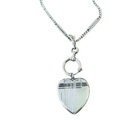Antique Art Deco sterling silver heart locket pendant with geometric engraving shown on a silver chain.