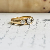 Antique three-stone diamond ring with old mine-cut diamonds bezel-set in platinum