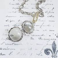 Pools of Light Rock Crystal Necklace with sterling silver chain on textured backdrop.