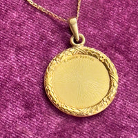 Antique gold love token necklace styled flat with visible gemstones and engraved border