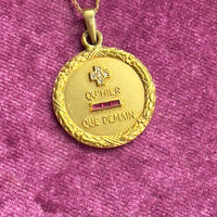 Round vintage French charm inscribed with “+ qu’hier – que demain” featuring diamond and ruby accents