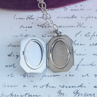 Open sterling silver locket showing interior photo compartments