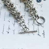 Close-up of the sterling silver toggle clasp on a vintage peppercorn necklace with 925 silver construction.