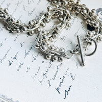 Close-up of vintage sterling silver peppercorn necklace showing bead ball helix links and handcrafted texture.