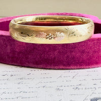 Close-up of engraved floral details on gold bangle