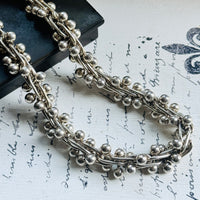 Detailed view of the vintage sterling silver peppercorn chain featuring sculptural bead ball helix links.