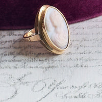 Gold ring with a white stone on a textured surface