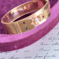 Victorian 14k gold hinged bangle with pearl center and red and blue starburst accents