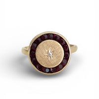 Victorian gold ring featuring garnet halo and diamond star detail