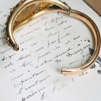 Antique gold filled lion head bangle shown open to reveal the hinged opening and smooth inner band