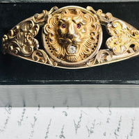 Close-up of the high-relief lion head on an antique gold filled bangle, red paste eyes and clear paste stone in mouth