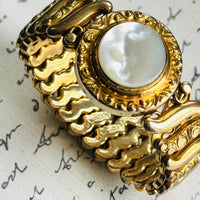 Close-up of the white Lucite center and engraved gold filled frame on a vintage Gloria sweetheart bracelet