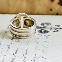 Tiffany Atlas sterling silver ring standing upright, showing the ribbed bands and loop