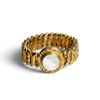 Vintage Gloria gold filled sweetheart expansion bracelet with round white Lucite center, angled view on white