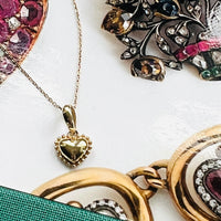 14k gold heart with a beaded border detailing.