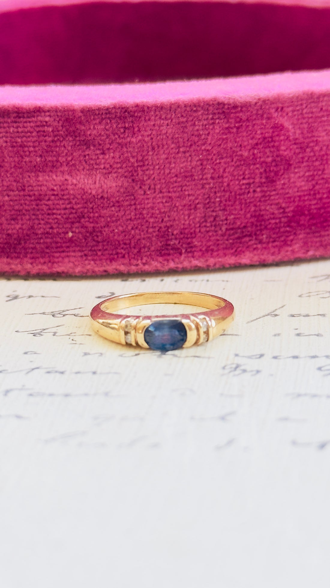 10K gold vintage ring featuring oval sapphire flanked by four diamond chips
