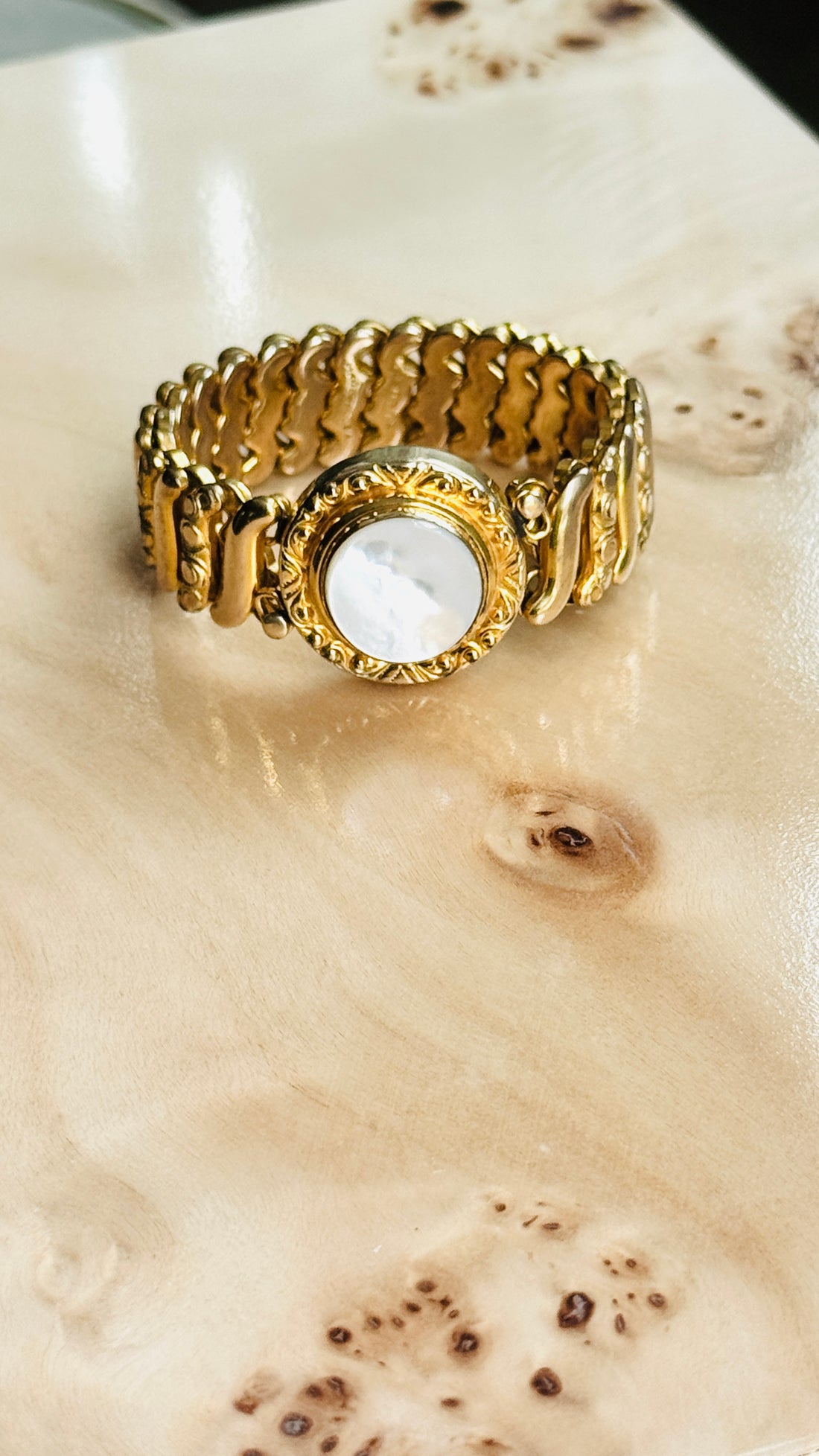 1940s gold filled sweetheart expansion bracelet with white Lucite center styled on burl wood