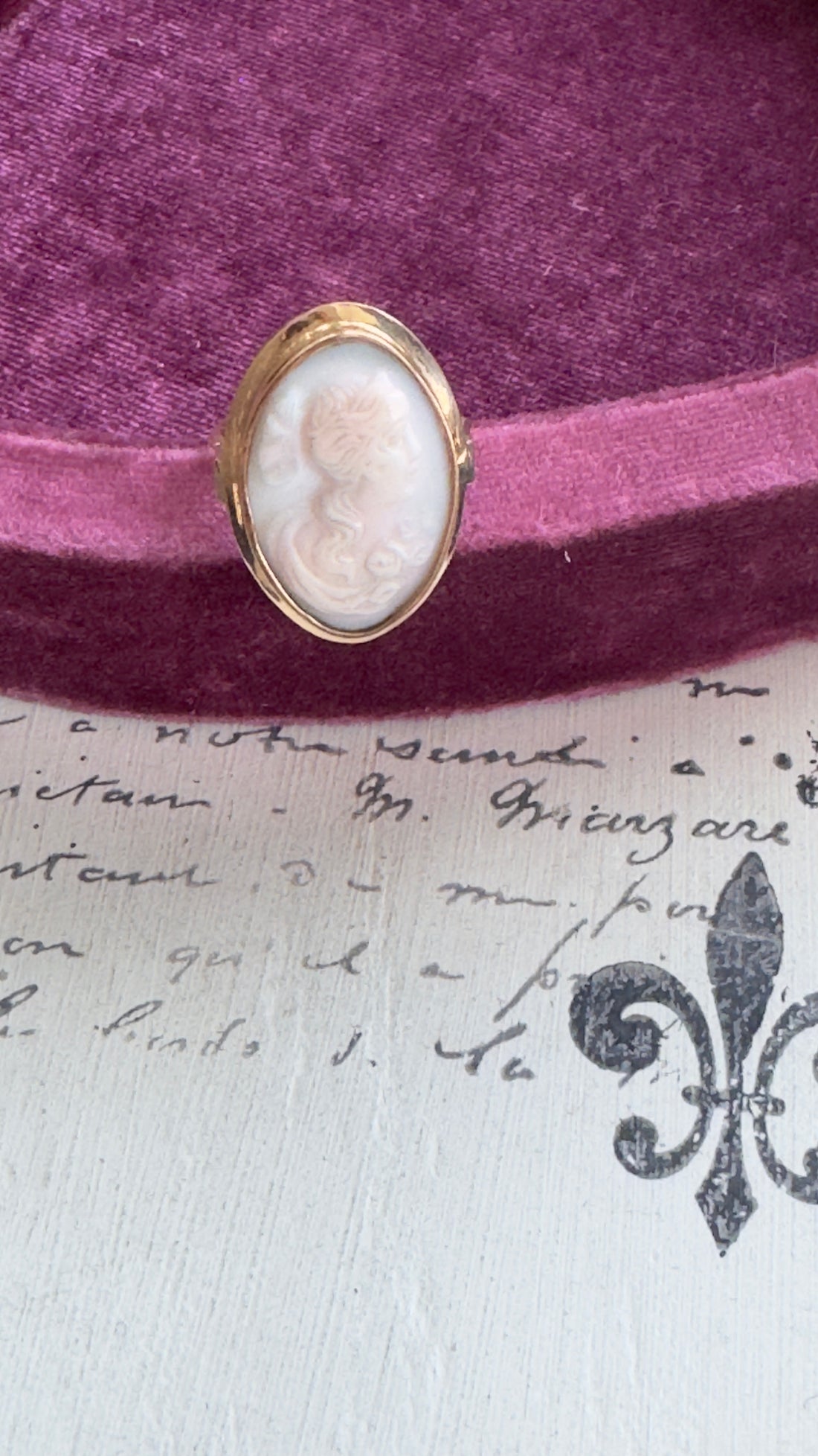Gold ring with a cameo on a purple fabric background