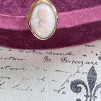 Gold ring with a cameo on a purple fabric background