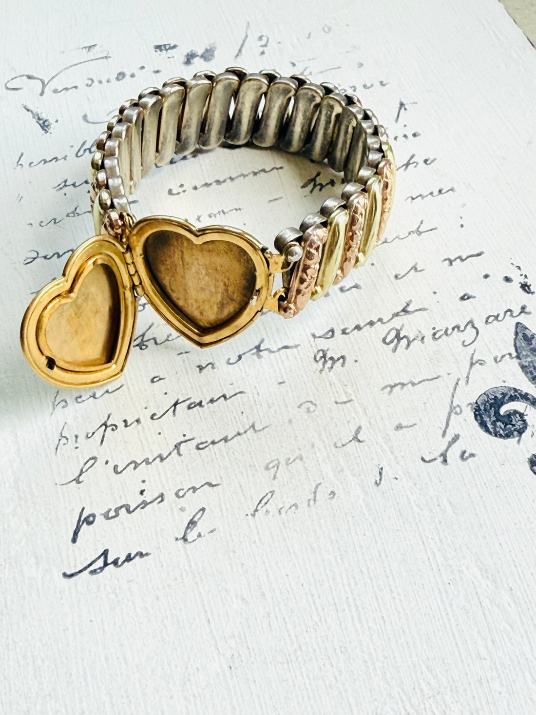 Open heart locket on sweetheart bracelet revealing space for two tiny photos.