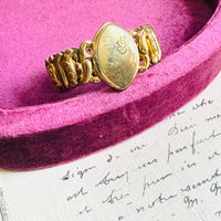 Vintage American Queen Pitman & Keeler sweetheart expansion bracelet with “LOVE” cartouche on pink velvet background.