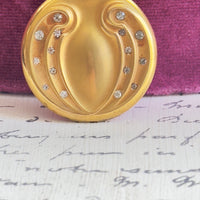 Gold-filled WH & Co. locket on long Victorian chain styled on a plum velvet jewelry box