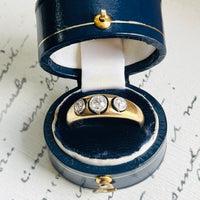 Antique diamond ring in a navy ring box, styled with vintage handwritten paper