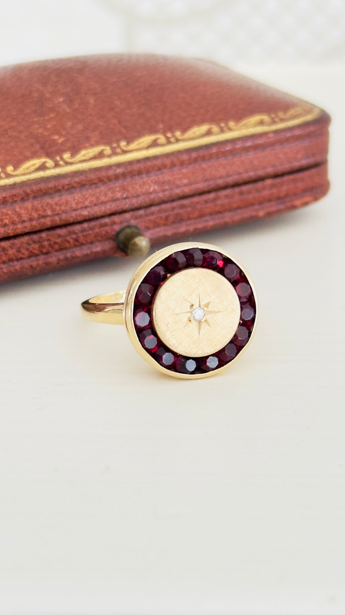 Antique garnet halo ring with diamond starburst in 14k gold