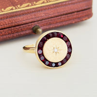 Antique garnet halo ring with diamond starburst in 14k gold