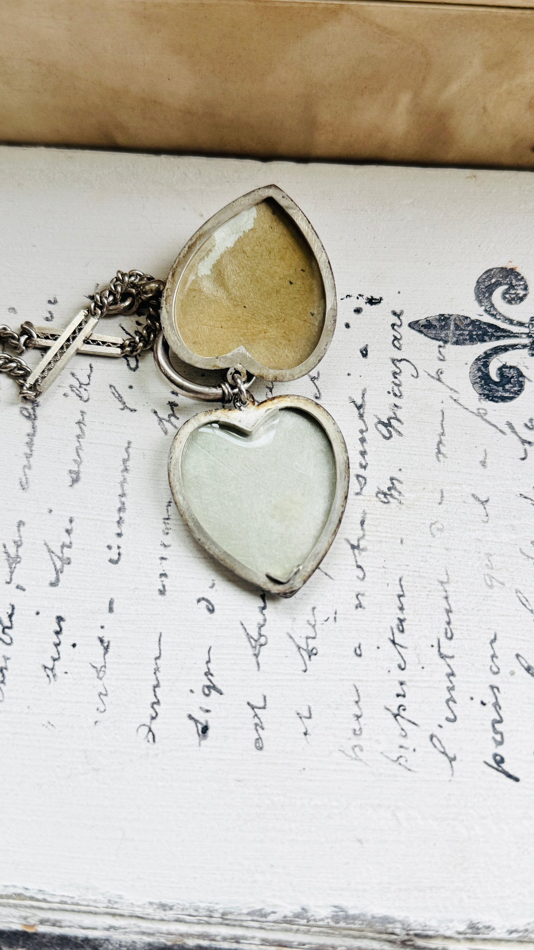 Antique sterling silver heart locket opened to reveal two compartments for photographs.