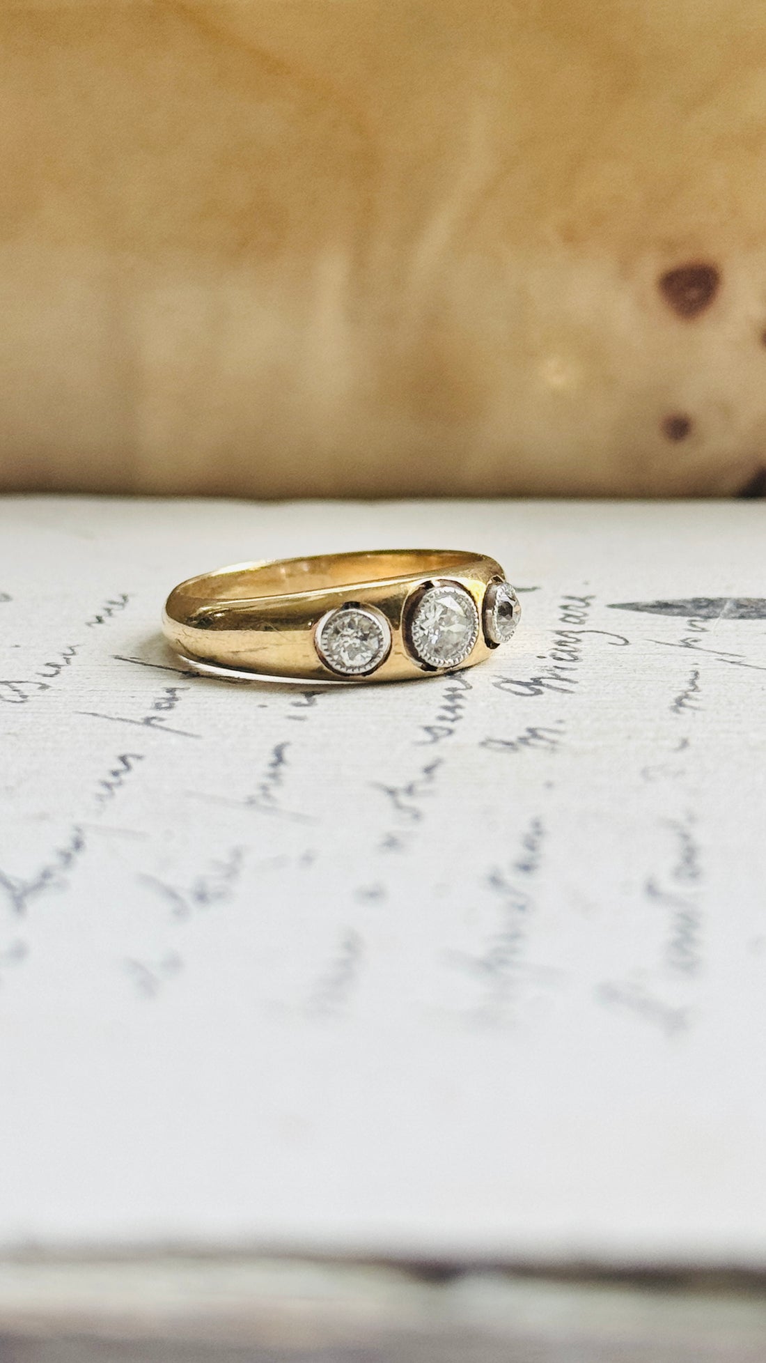 Antique three-stone diamond ring with old mine-cut diamonds bezel-set in platinum