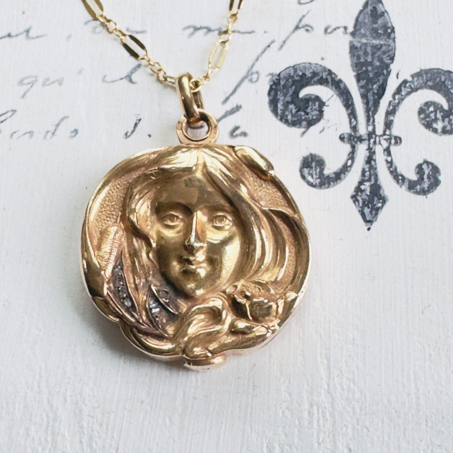 18k gold Art Nouveau photo locket with a raised female image adorned with diamonds