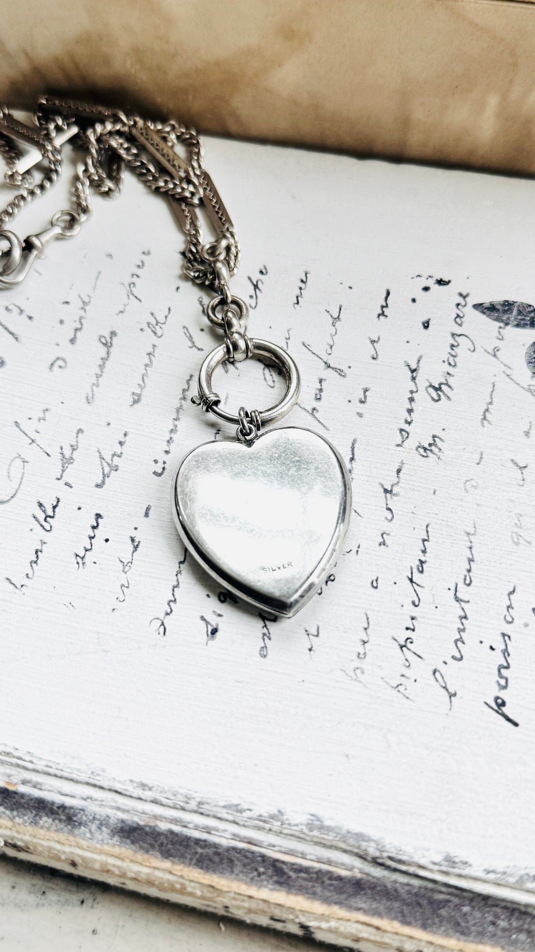 Back of antique sterling silver Art Deco heart locket pendant with smooth polished reverse.