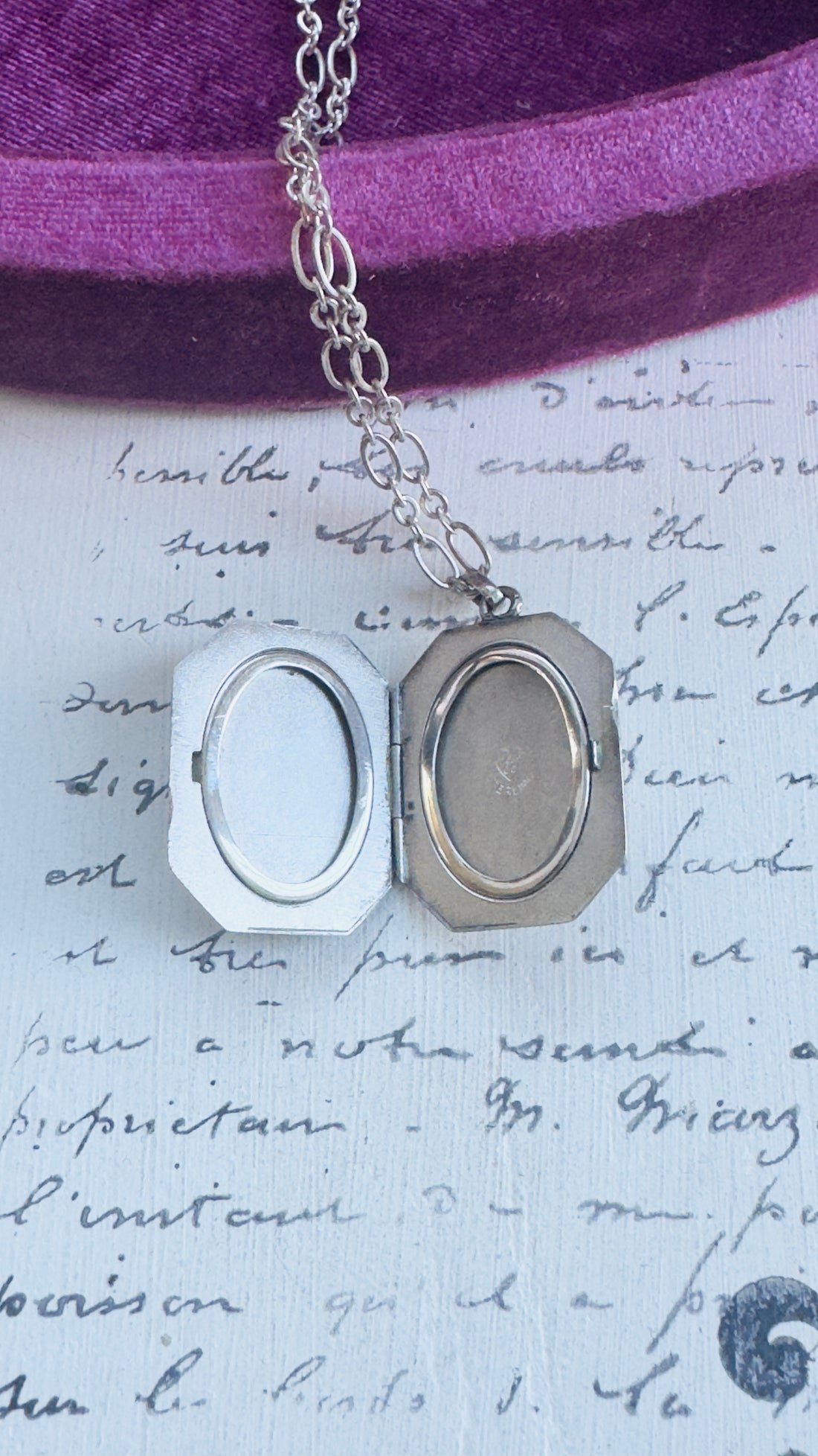 Open sterling silver locket showing interior photo compartments