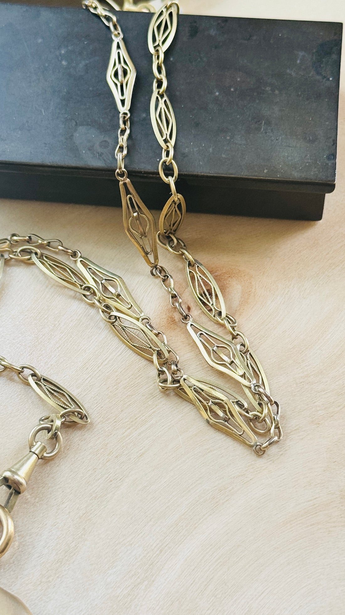 Close-up detail of the antique French ORIA watch chain featuring original dog clips and distinctive elongated links.
