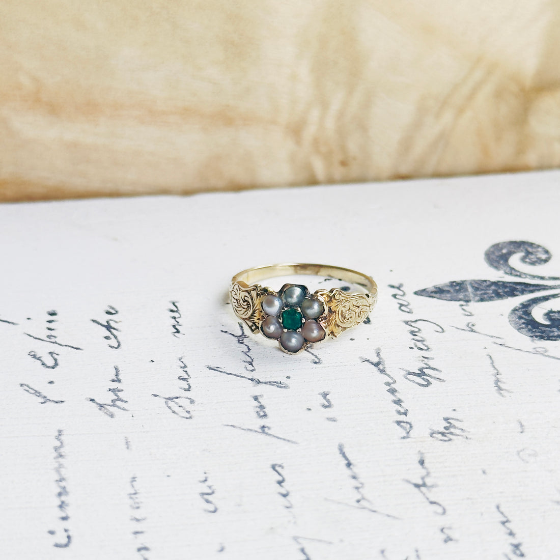 Close-up of Victorian seed pearl emerald ring with engraved gold band, one of a kind antique ring
