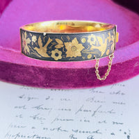 Close-up of bird and floral motif on vintage damascene-style bracelet