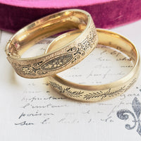 Close-up of etched detail on gold bangle bracelet.
