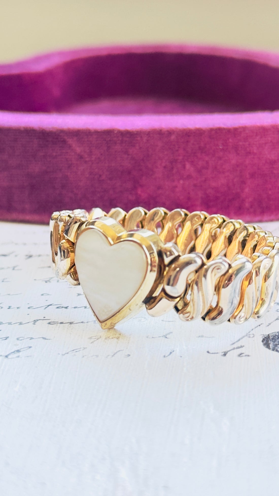 Close-up of mother of pearl heart center on vintage Speidel bracelet
