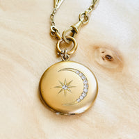 Close-up of the original Victorian celestial locket featuring a crescent moon and star with original paste stones.