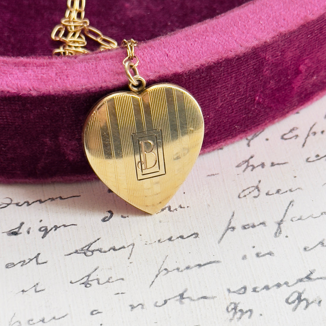 Close-up of vertical etched detailing on gold heart locket