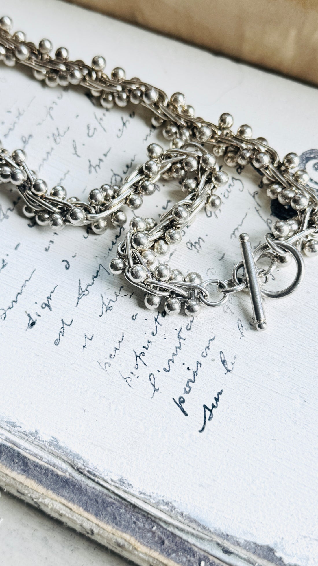 Close-up of vintage sterling silver peppercorn necklace showing bead ball helix links and handcrafted texture.