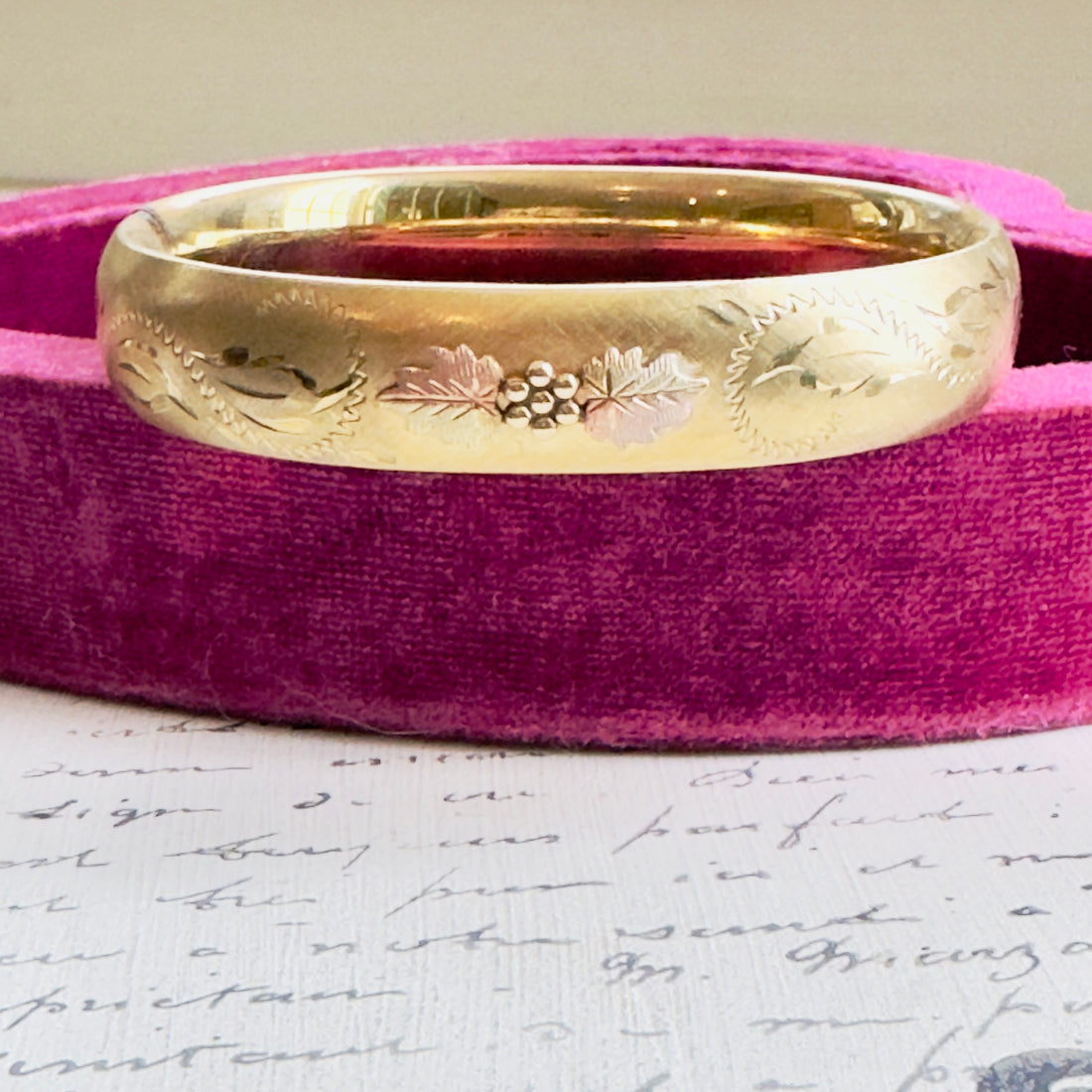 Close-up of engraved floral details on gold bangle
