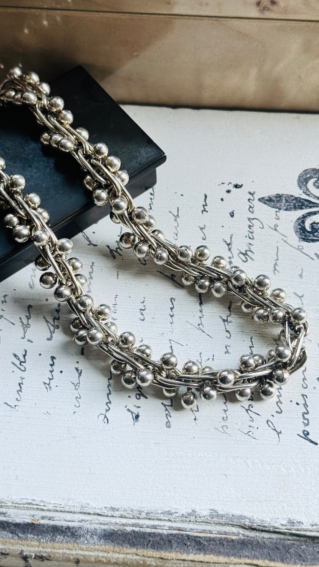 Detailed view of the vintage sterling silver peppercorn chain featuring sculptural bead ball helix links.