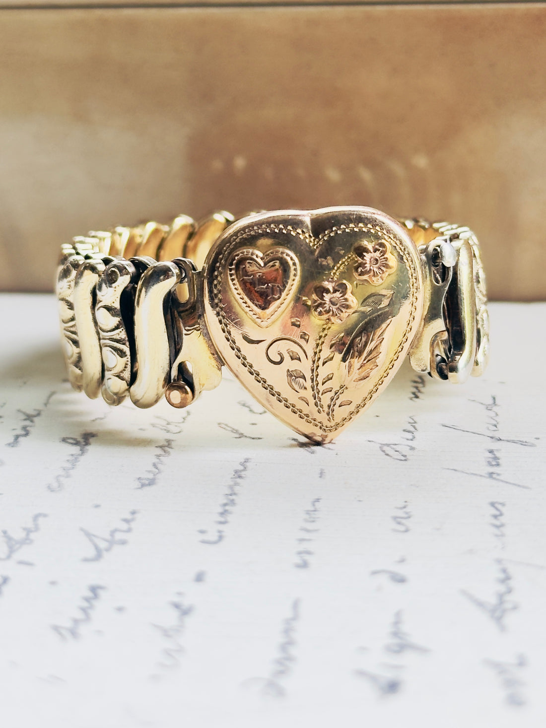 Jewel Guild mid-century sweetheart bracelet, gold filled over sterling silver base with milgrain heart face, pink enamel flowers, and LLD monogram
