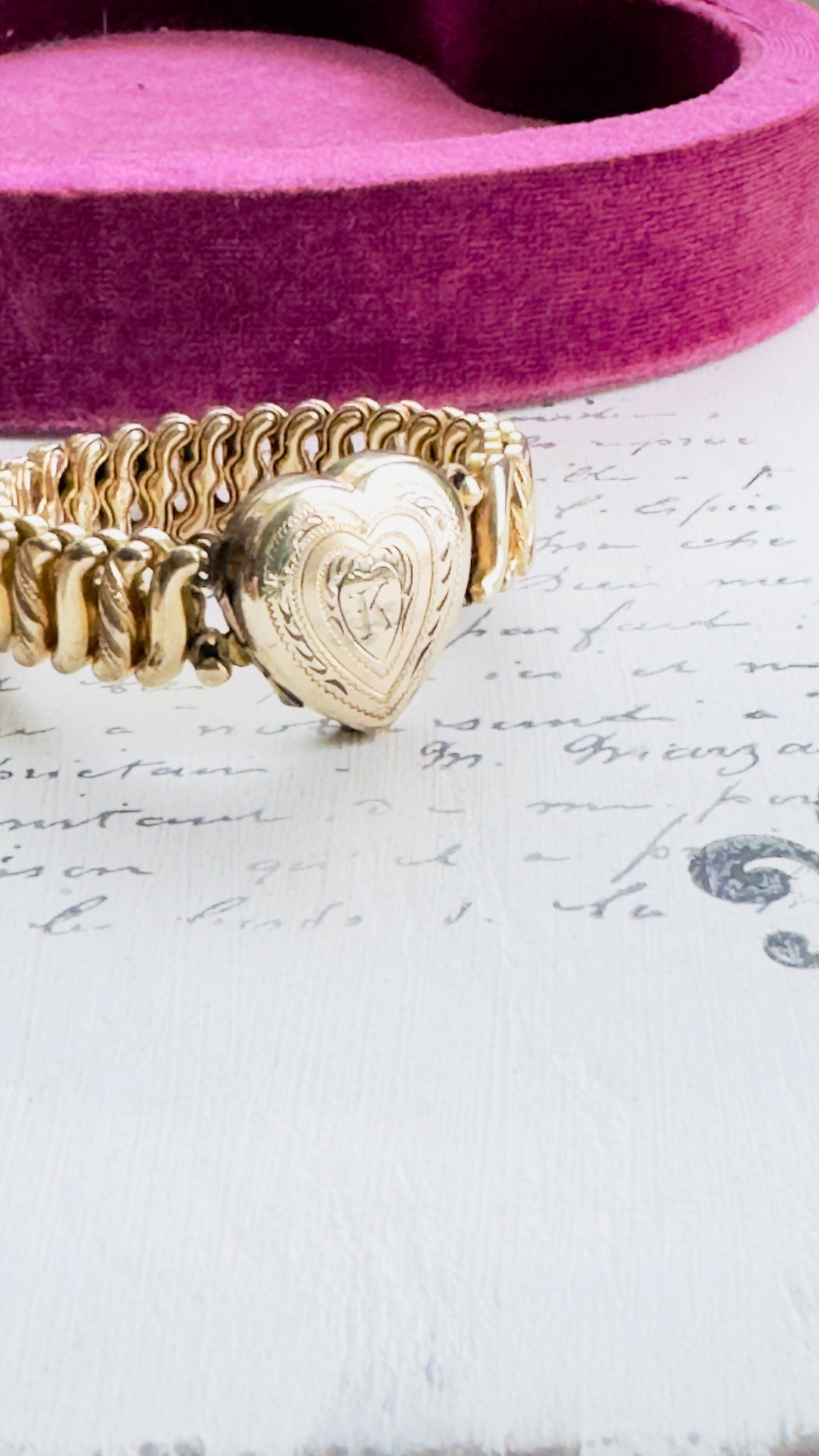 Side view of gold-tone expansion link design and locket craftsmanship.