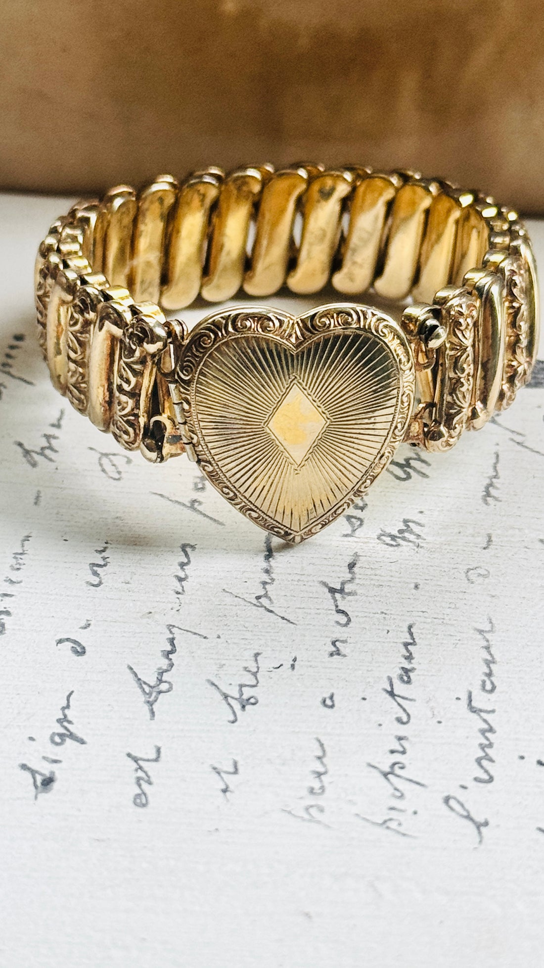 Ladifair gold filled sweetheart bracelet with engraved heart locket, displayed on antique paper"
